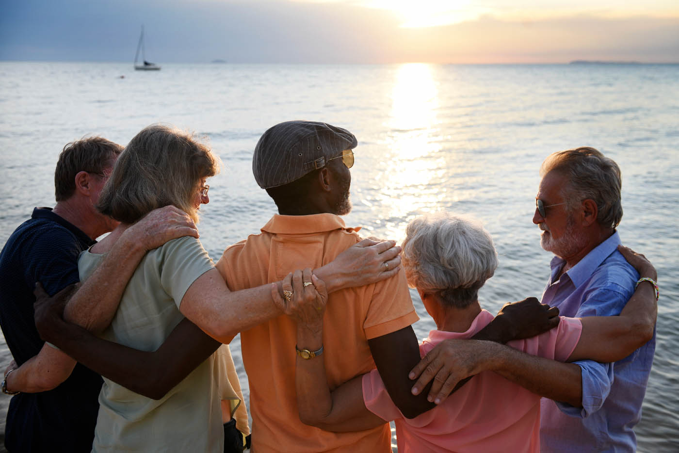 A group of older people watching a sunset at the beach while enjoying the benefits of red light therapy at Light Lounge Evergreen.