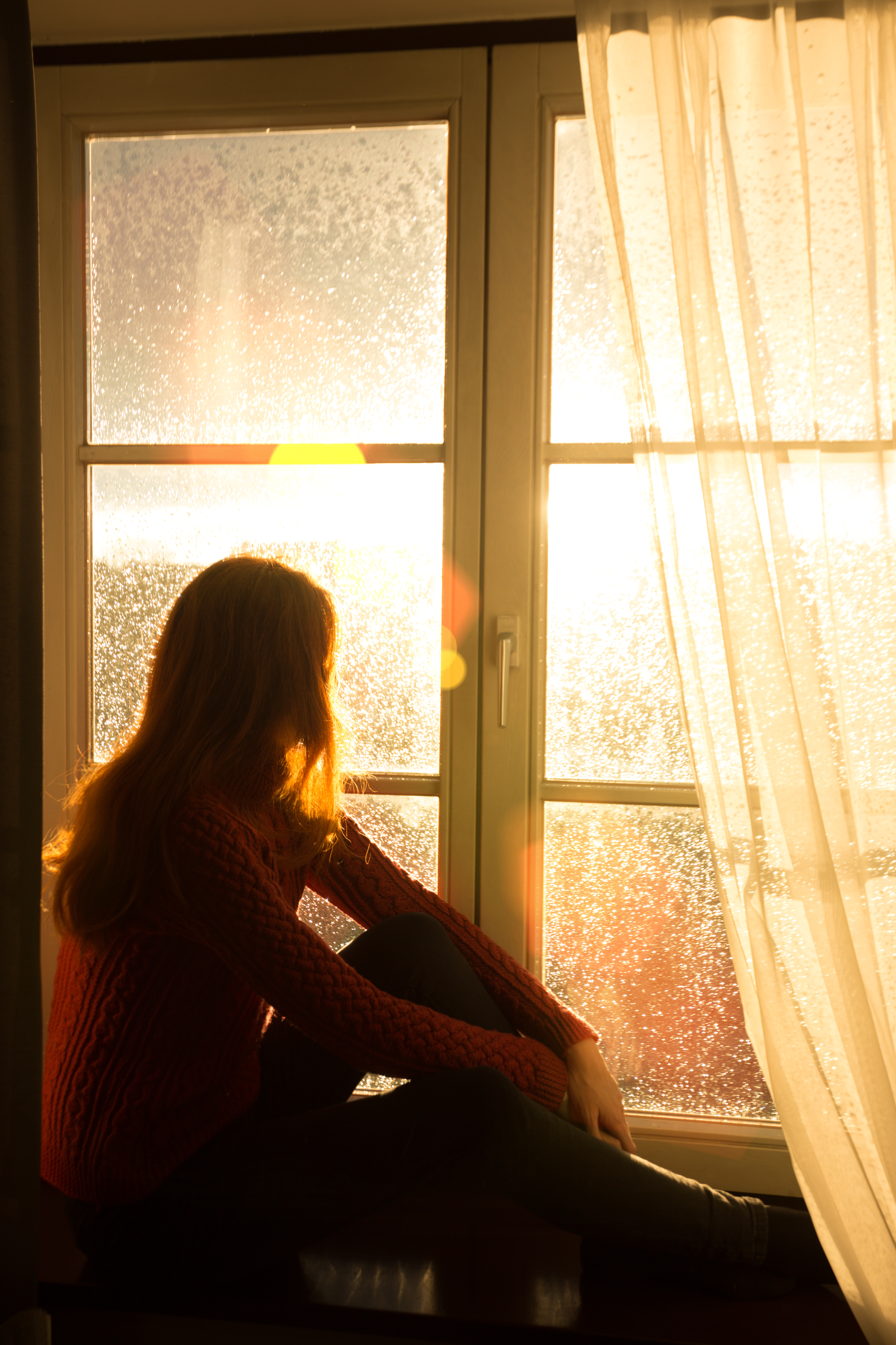 A woman sitting by her window - find Southlake multiple sclerosis treatment today with Light Lounge.