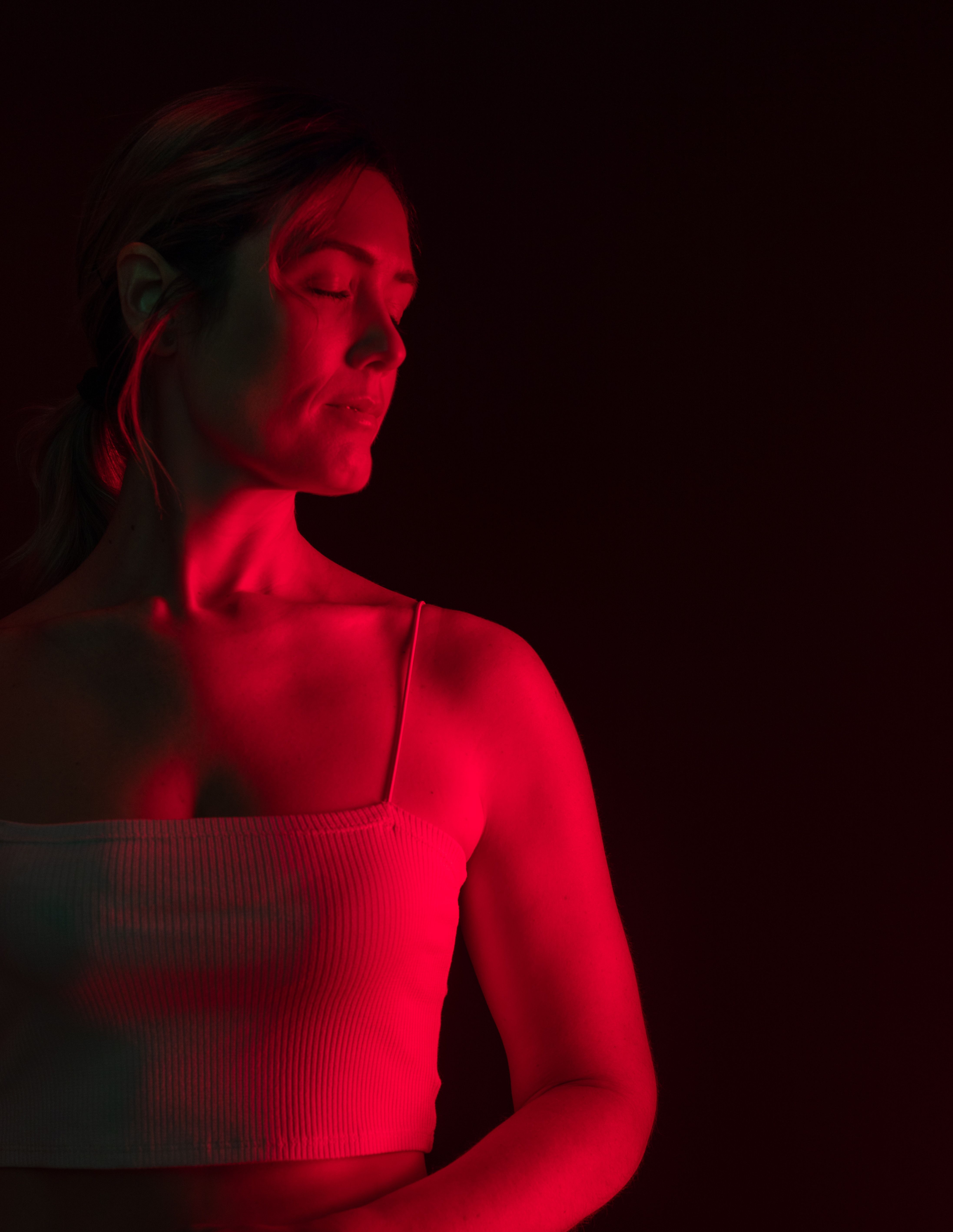 A woman experiencing the anti-inflammatory properties of photobiomodulation red light therapy.