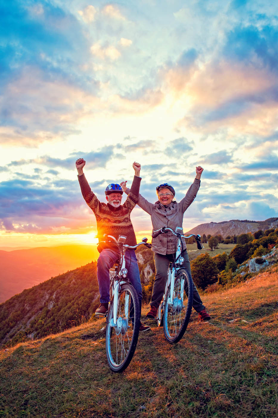 A senior couple biking pain-free into the sunset thanks to Light Lounge's knee pain treatment.